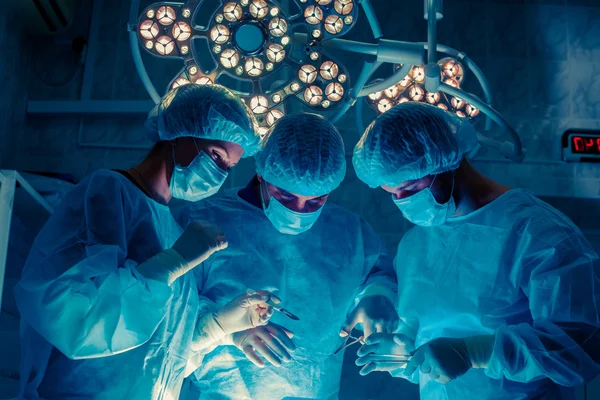 Equipe de Cirurgiões que trabalha com Monitoramento de Paciente em Cirurgia — Fotografia de Stock