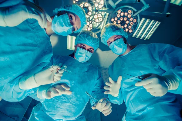 Chirurdzy, stojąc nad pacjenta przed zabiegiem — Zdjęcie stockowe