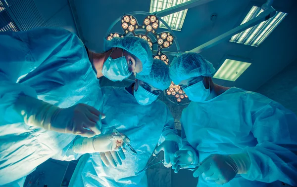 Chirurdzy, stojąc nad pacjenta przed zabiegiem — Zdjęcie stockowe