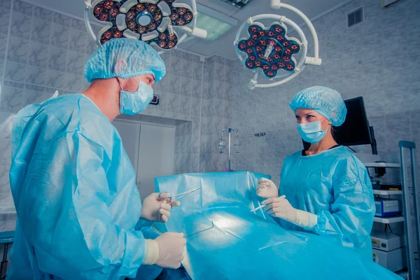 Surgeons team working with Monitoring of patient in surgical operating room. breast augmentation