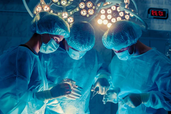 Kirurger team som arbetar med övervakning av patient i kirurgisk ope — Stockfoto