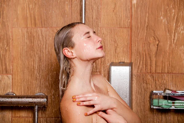 Mooie vrouw in de douche. Met de ogen gesloten — Stockfoto