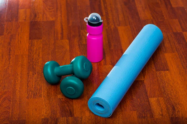 Two dumbbells with water bottle and yoga mat, sporty lifestyle concept — Zdjęcie stockowe