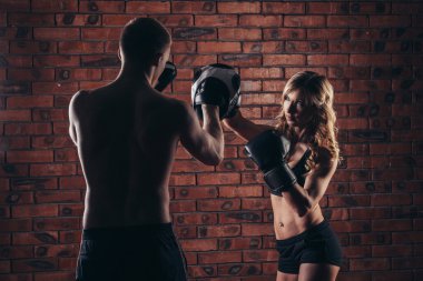 Duvara karşı spor salonunda boks eldivenli eğitim şirin esmer kadın