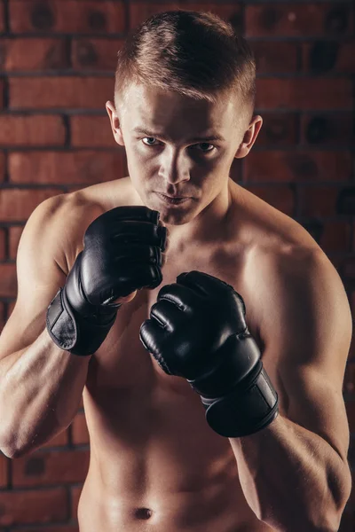 Portrait of mma fighter in boxing pose against brick wall — Stock Photo, Image