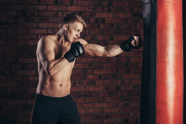 Entrenamiento de boxeador en un saco de boxeo en el gimnasio. —  Fotos de Stock