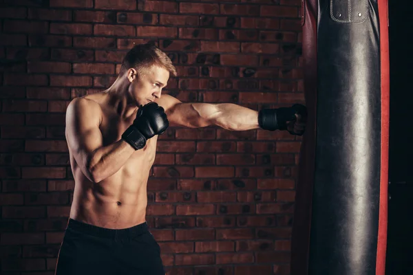 Allenamento boxer su un sacco da boxe in palestra. — Foto Stock