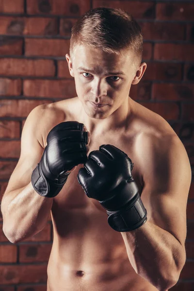 Portrait of mma fighter in boxing pose against brick wall — Stock Photo, Image