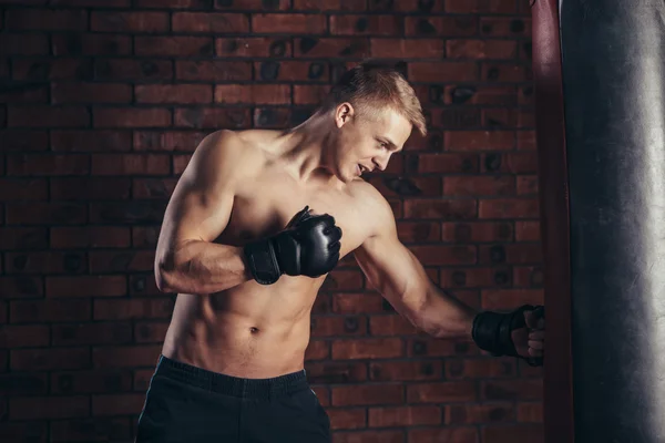 Entrenamiento de boxeador en un saco de boxeo en el gimnasio. —  Fotos de Stock