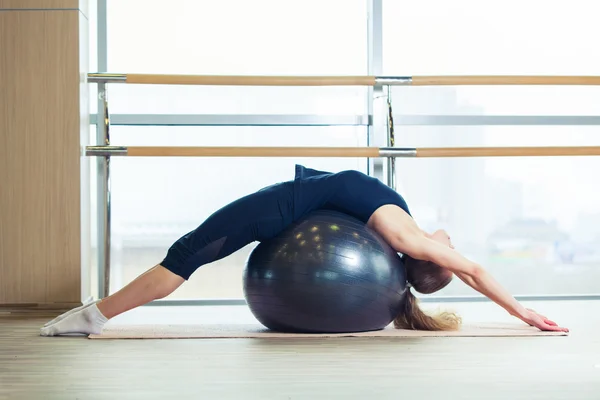 Mujer en una pelota de fitness en el gimnasio —  Fotos de Stock