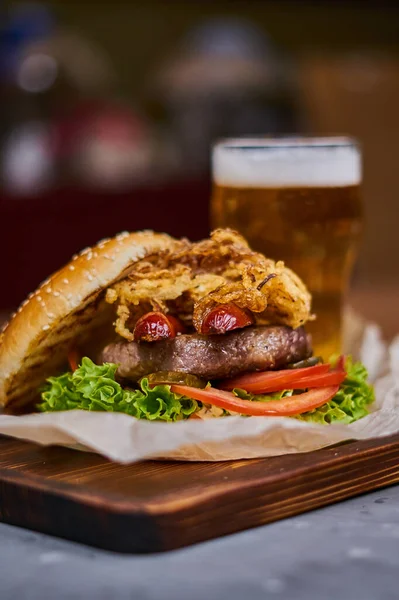 Šťavnatý lahodný burger na dřevěné desce — Stock fotografie