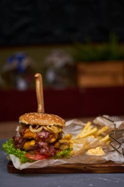 Çift pirzola ve tahtadan yapılmış patates kızartması ile nefis bir hamburger.