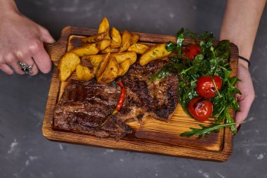  Tahta bir tahtada patates dilimli acı biberli biftek.. 