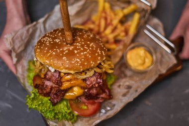 Çift pirzola ve tahtadan yapılmış patates kızartması ile nefis bir hamburger.