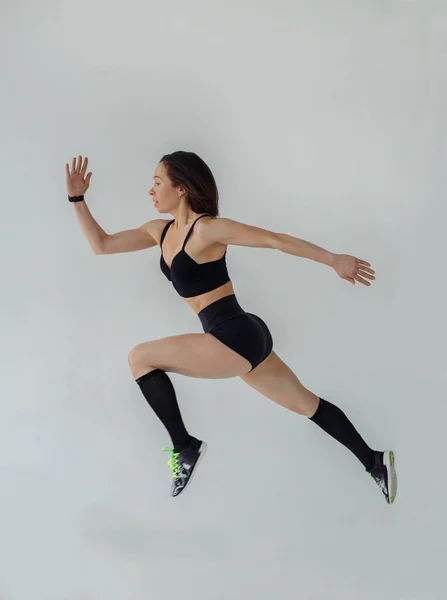 Sportif Görünümlü Bir Kadın Beyaz Bir Arka Plana Atlıyor — Stok fotoğraf