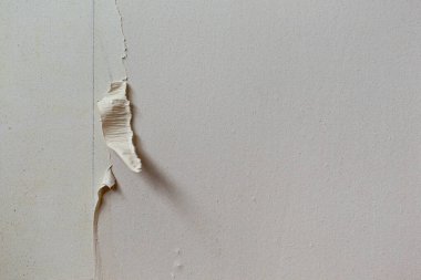 Yırtık duvar kağıdıyla kaplı kaba bir duvarın soyut dokusu. Dokuları Onar
