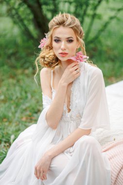 Baharda, parkta beyaz bir elbise giymiş bir kadının portresi. Genç bir kızın güzel portresi.