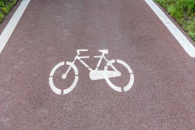 Ormanda yol işaretleri olan bir bisiklet yolu. Ufkun ön planı ve derinliği.
