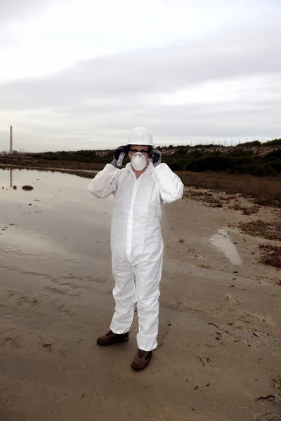 Worker in a protective suit examining pollution Royalty Free Stock Images