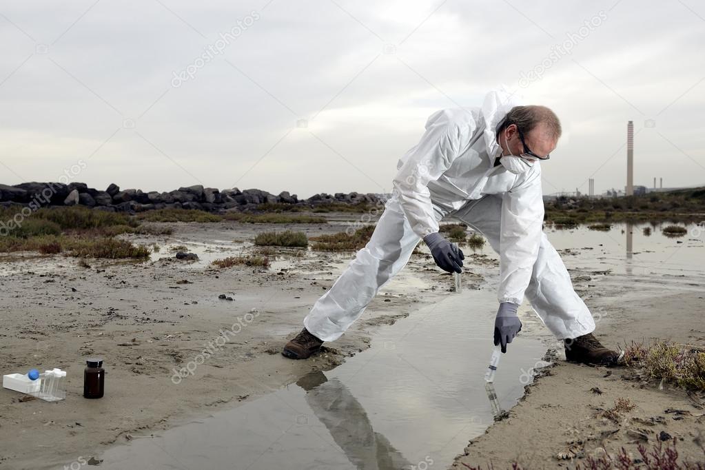 Worker in a protective suit examining pollution