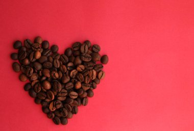 Pembe arka planda kahve çekirdeğinin kalbi.