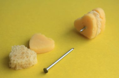 Peynir ve ekmeğin kalbi sarı arka planda bir karanfil üzerinde