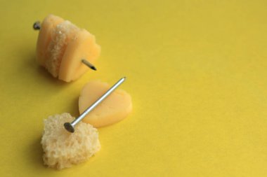 Peynir ve ekmeğin kalbi sarı arka planda bir karanfil üzerinde