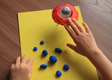 modeling of an alien for the day of cosmonautics from plastic mass with a flying saucer