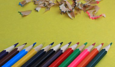 Sarı arka plan üzerine çizim yapmak için renkli kalemler