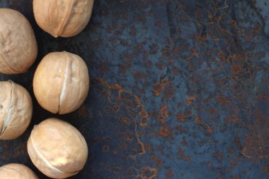 Metal bir arka planda deride yuvarlak cevizler.