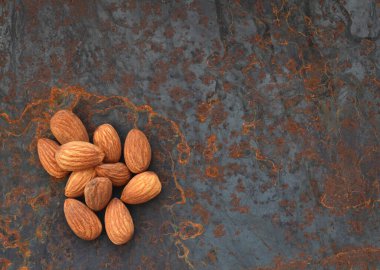 Metalik arka planda soyulmuş fındık bademleri.