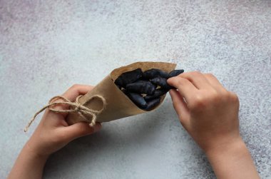 Elinde böğürtlenli kağıt torba olan bir çocuğun elleri.