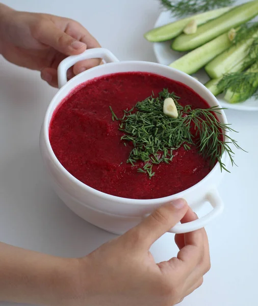 Kinderhände mit einer Tasse kalte Rote-Bete-Suppe mit Kräutern — Stockfoto