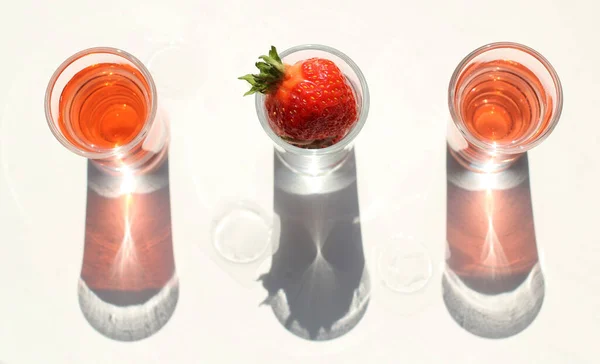 Strawberry compote tincture with ice in glass glasses with strawberries and ice cubes — Stock Photo, Image