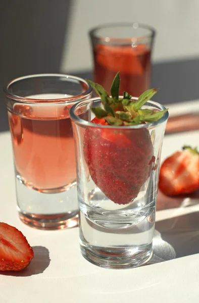 Jordgubbskompott tinktur med is i glas med jordgubbar och isbitar — Stockfoto