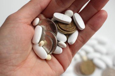 Bozuk paralarla ve arka planda farklı tabletlerle kadınların eli