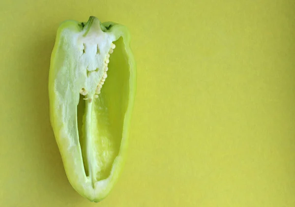 Green bell pepper in section with creative face on a yellow background — Stock Photo, Image