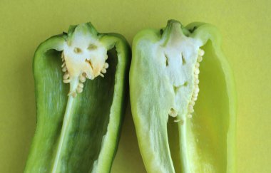 Yeşil dolma biber bölümü, sarı arka planda yaratıcı bir yüz.