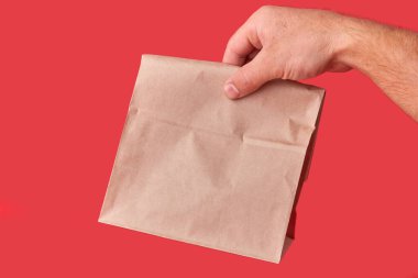 Erkeğin elinde kahverengi bir eko-çantadan yapılmış bir paket var. Yemek teslimatı.