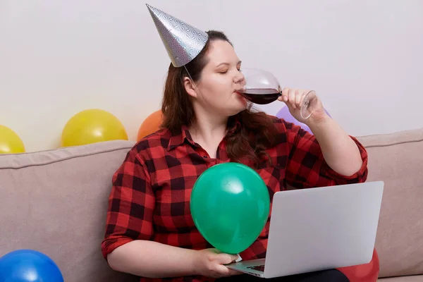 Una mujer celebra su cumpleaños durante la pandemia y bebe vino tinto. —  Fotos de Stock