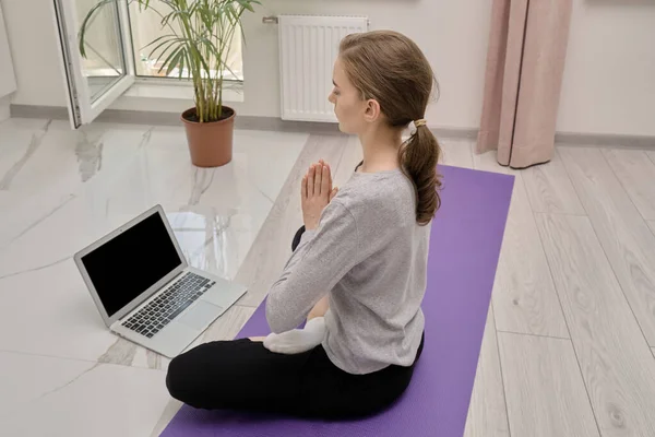 Сторона зору жінки, яка відпочиває в позиції лотоса, вивчаючи йогу онлайн. — стокове фото