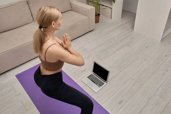 Вид ззаду молодої блондинки, вивчаючи пози йоги онлайн . — стокове фото