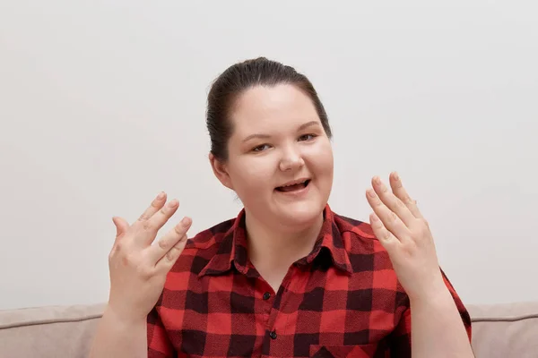 Eine junge übergewichtige Frau spricht emotional und blickt in die Kamera. — Stockfoto