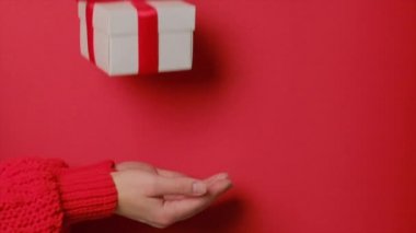 Kırmızı kurdeleli bir kutuda bir hediye yukarıdan kızların eline geçiyor..