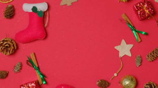Kerst wervelingen, Kerst rode achtergrond, versierd met dennenappels, glitter. — Stockvideo