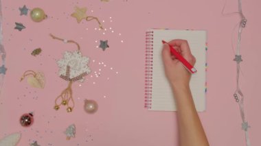 El, Not Defteri yapılacaklar listesindeki bir kağıt parçasına kırmızı bir kalem yazar.