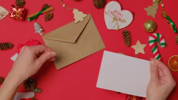 Flickan ordnar halv bokstaven och lägger hantverk kuvertet. — Stockvideo