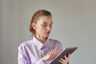 Güzel genç bir kadın tablet kullanır. Doğal makyajlı bir kadın yüzü.