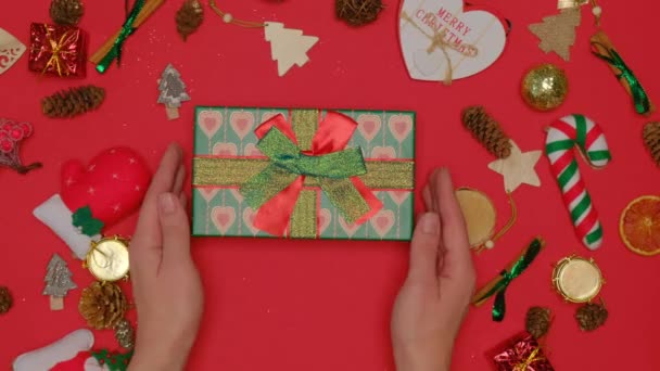 Ležel. Dívka vezme krásnou vánoční krabici od stolu. — Stock video