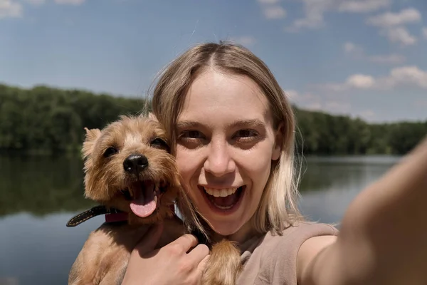 Bela feliz jovem loira mulher leva um selfie com seu amado cão. — Fotografia de Stock